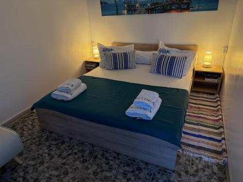 a bedroom with a bed with two towels on it at Căsuțele Allora in Murighiol