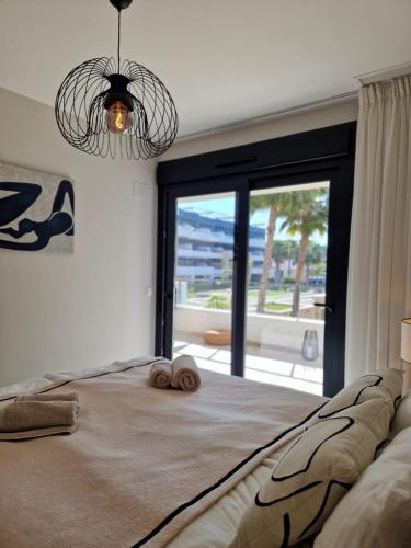 a bedroom with a large bed with a large window at Flamenca Village Apartment SALSA in Orihuela Costa
