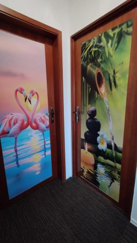 two framed pictures of flamingos in a room at Birken Loft am Meer in Neustadt am Rübenberge