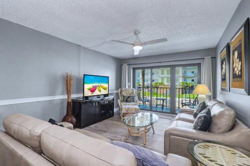 a living room with a couch and a tv at Madeira Place 205 in St. Pete Beach