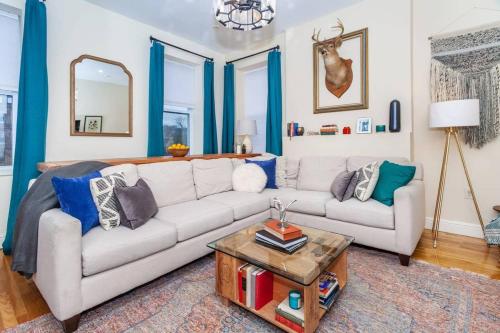 a living room with a couch and a table at Expansive Essential Triplex near T in Boston
