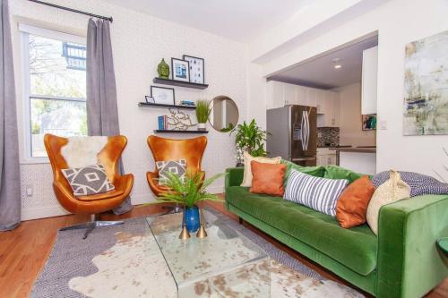 a living room with a green couch and chairs at Expansive Essential Triplex near T in Boston