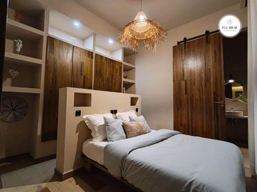 a bedroom with a large bed and a chandelier at Villa NDOL'AM in Ebomé