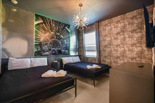 a bedroom with two beds and a couch and a chandelier at Resort Villa 15BR Veranda Palms in Kissimmee