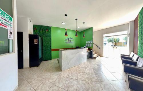 a restaurant lobby with a green wall and a counter at Hotel Colina Verde in Lucas do Rio Verde