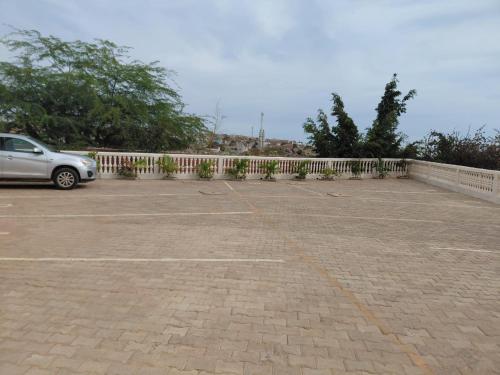 a car parked in a parking lot next to a fence at Apparthotel Le SALY Beach yenne in Toubab Dialaw
