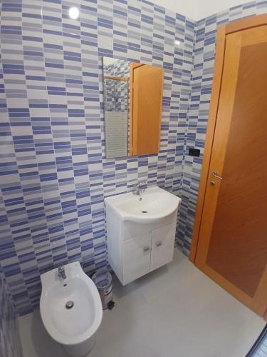 a bathroom with a toilet and a sink and a mirror at Victoria Home in Eboli