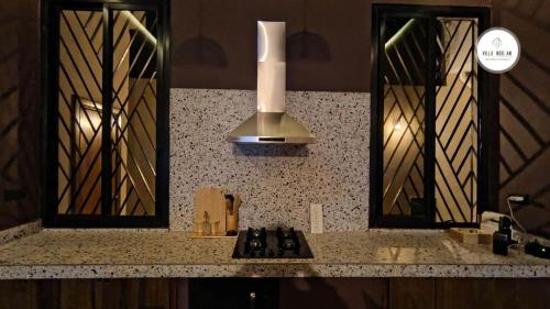a kitchen counter with two mirrors and a sink at Villa NDOL'AM in Ebomé