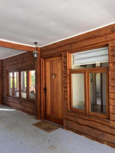 an empty room with a wooden door and windows at Cabaña Castaño in Villarrica