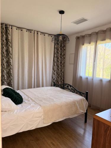 a bedroom with a bed and a window with curtains at Entire house 6 guests Mountain view in Luri