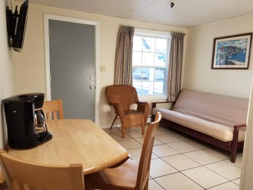a room with a table and a bed and a table and chairs at Sea Cliff House Motel in Old Orchard Beach
