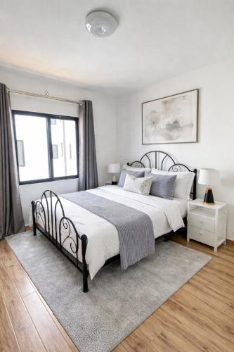a white bedroom with a large bed and a window at GL Luxe Suites in Tatu City