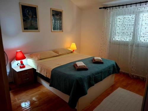 a bedroom with a bed with two towels on it at Sunshine Apartment in Dobrota