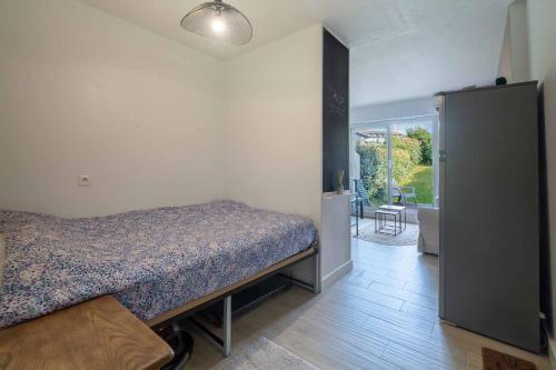 a bedroom with a bed and a door to a patio at Charmant studio climatisé à deux pas de la plage! in Anglet