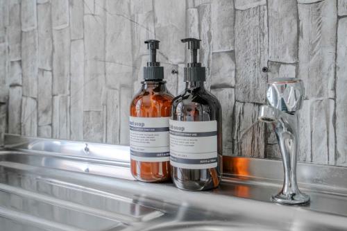 two bottles of soap sitting on a bathroom sink at The Castletown Collection in London