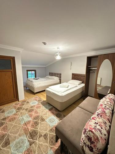 a large room with two beds and a couch at Çam Otel 2 in Uzungöl