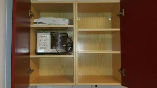a cupboard with a microwave and a blender in it at Billet Junior in Fredrikstad