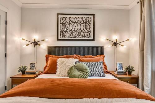 a bedroom with a large bed with an orange comforter at Luxe Boston Condo Near T in Boston