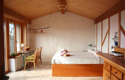 a bedroom with a bed and a table and chairs at La Forge - calme absolu avec vue sur les Pyrenées in Villarzel-du-Razès