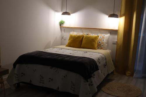a bedroom with a bed with two yellow pillows at Souto 25 - T0 na Régua in Peso da Régua