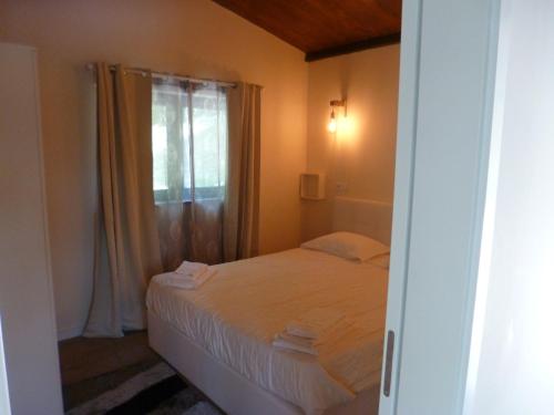 a small bedroom with a bed and a window at Casinha de campo in Geres