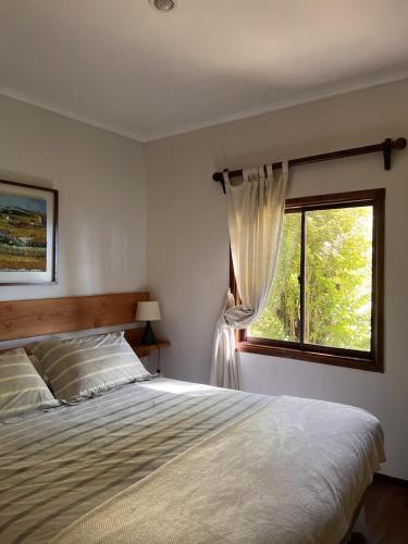 a bedroom with a large bed and a window at Cabaña Coihue in Pucará