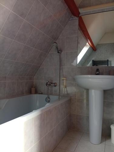 a bathroom with a bath tub and a sink at Le Green de Bellême in Bellême