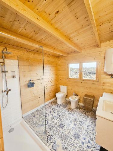 a bathroom with a shower and a toilet and a sink at Nido de mar & Nido de Paola in Mazo