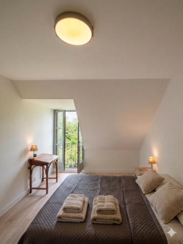 a bedroom with a large bed and a desk at Le Green de Bellême in Bellême