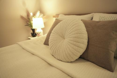 a white pillow sitting on top of a bed at Vintage Apartman Gyula in Gyula