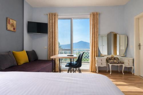 a hotel room with a bed and a window with a view at Apartments Vista Mar in Orikum