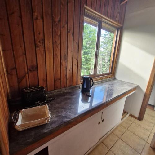 a kitchen counter with a coffee maker on it at Cabaña Pino Oregón in Pucará