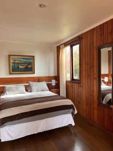 a bedroom with a large bed and a mirror at Cabaña Pino Oregón in Pucará