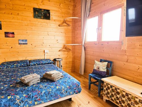 a bedroom with a bed and a wooden wall at Nido de mar & Nido de Paola in Mazo