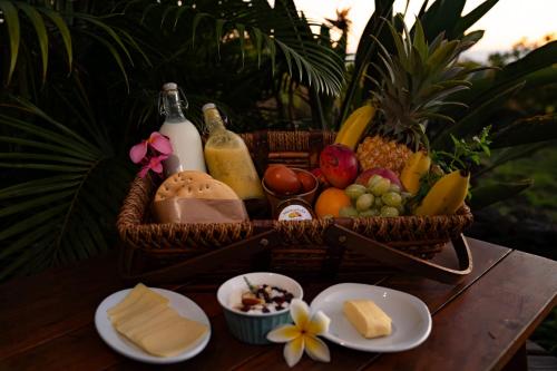 a basket of cheese and other foods on a table at Kona Koa Lodge in Hanga Roa