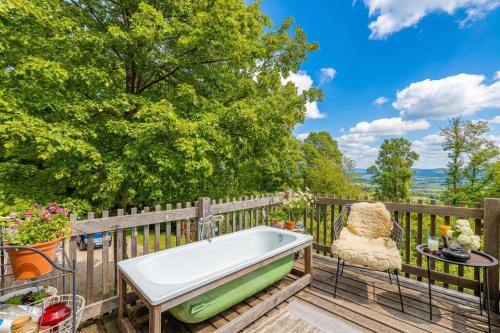 a bath tub on a deck with a fence at Tiny House Bibi /w Private Garden - Happy Rentals in Dragatuš