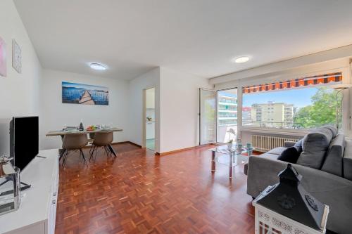 a living room with a couch and a table at Lido Apartment Locarno with Balcony and Parking - Happy Rentals in Locarno