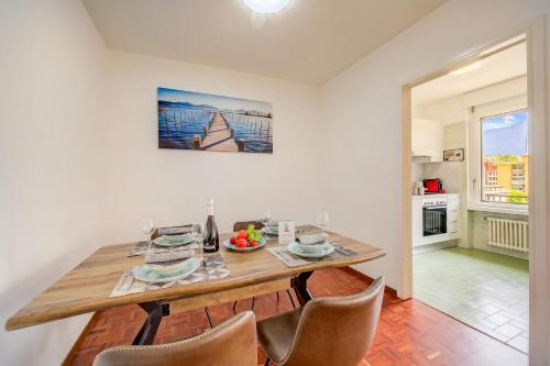 a dining room with a wooden table and chairs at Lido Apartment Locarno with Balcony and Parking - Happy Rentals in Locarno