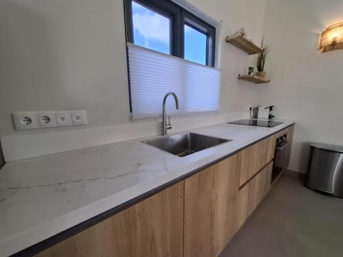 a kitchen with a sink and a window at Emma Luxury Pool Suites Resort in Willemstad