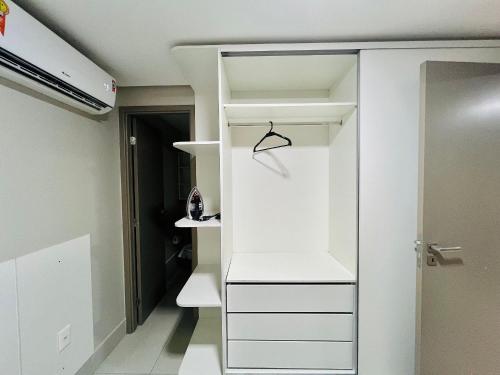 a closet with white drawers and a shelf at Cabo Branco - Fortune in Tambaú