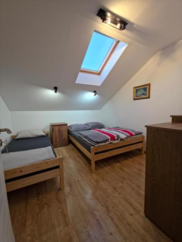 two beds in a room with a skylight at Sense Loft in Leskovac