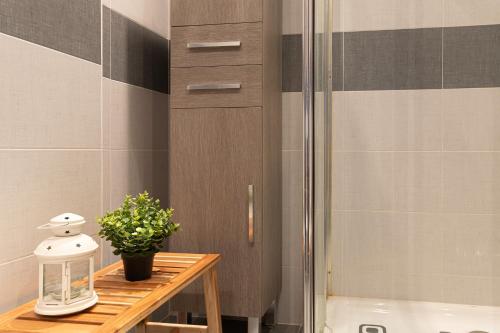 a bathroom with a shower and a table with a plant at Apartamento en Bádames in Bádames