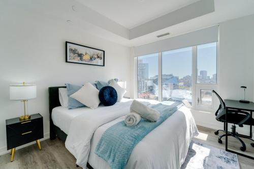 a bedroom with a bed with a desk and a window at Modern Downtown Condo with Gym in Kitchener