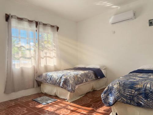 a bedroom with two beds and a window at Paradise Renewed Beach House for Deep Relaxation in El Cuyo