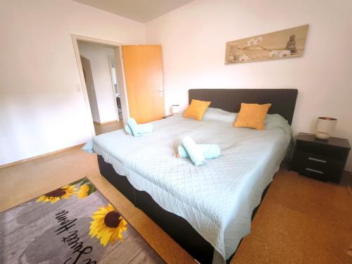 ein Schlafzimmer mit einem großen Bett und gelben und blauen Kissen in der Unterkunft Feriennest Faust in Altenmarkt an der Alz