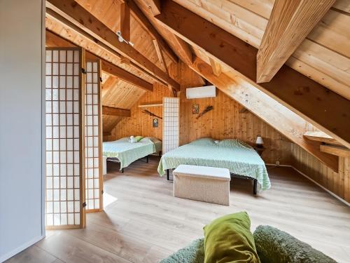 two beds in a room with wooden ceilings at La Maison des Jeux in Saint-Maur
