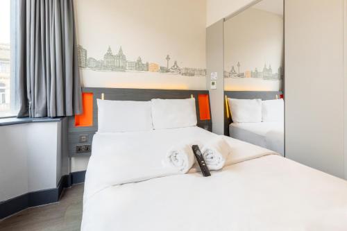 a hotel room with two beds and a mirror at easyHotel Liverpool in Liverpool