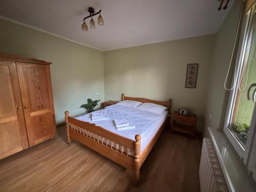 a bedroom with a wooden bed and a window at Pod Daglezją in Łagów