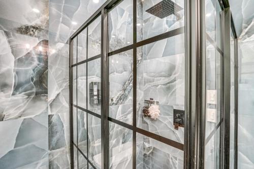 a shower with a glass door in a bathroom at Walkable Schenectady Getaway: 2-Unit Campus Hub in Schenectady