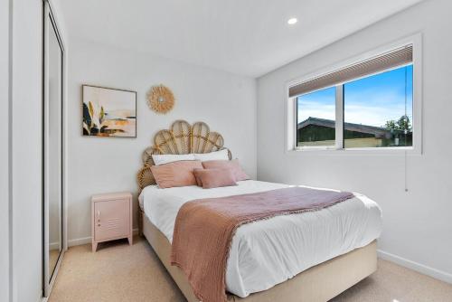 a white bedroom with a large bed with a window at Renovation, location, relaxation in Twizel